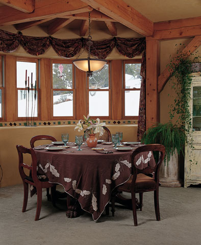 
A cozy view of the meadow surrounds the heirloom dining table, chairs, and place settings that belonged to Paula’s mother. Guelberth designed the round nook to accommodate the table, where Paula enjoys her morning tea while gazing out at the meadow.
